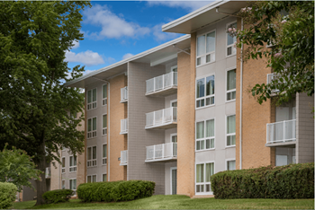 An apartment building with balconies and a lawn